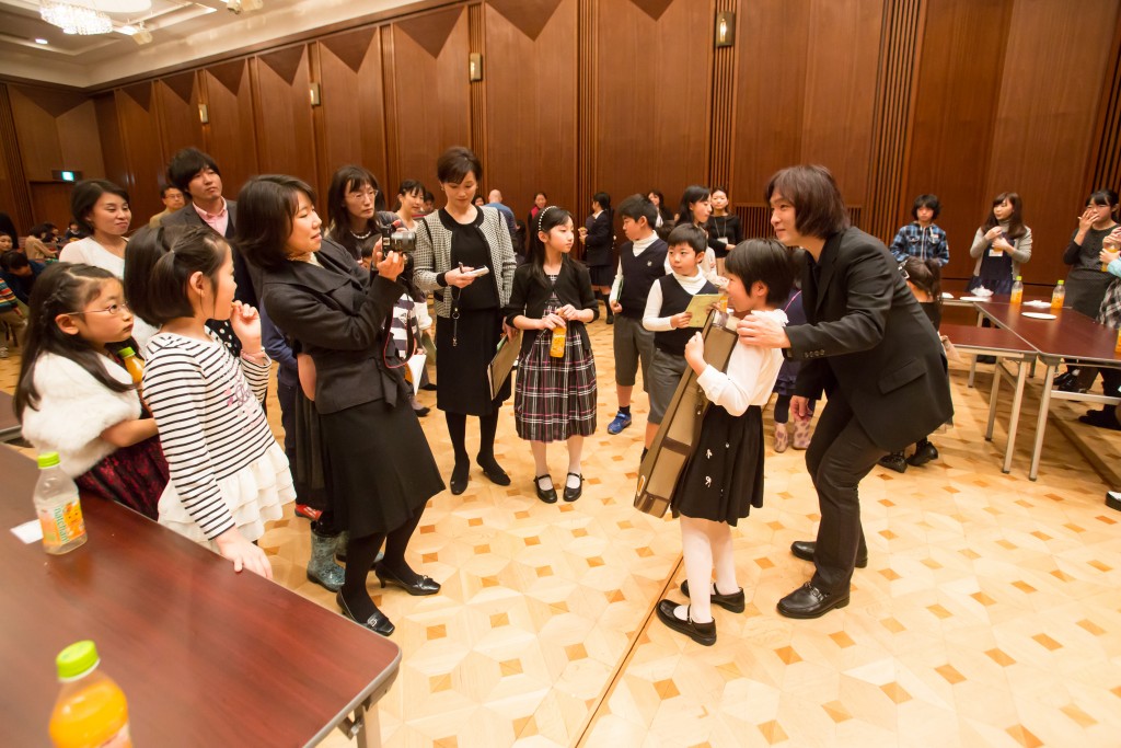 指揮者 飯森範親さんとオーケストラのメンバーを囲んで